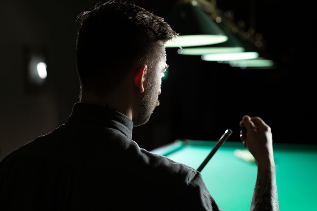 Close up of a unrecognizable man chalking pool cue