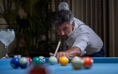 Man Playing Pool Inside Elegant Home at Night