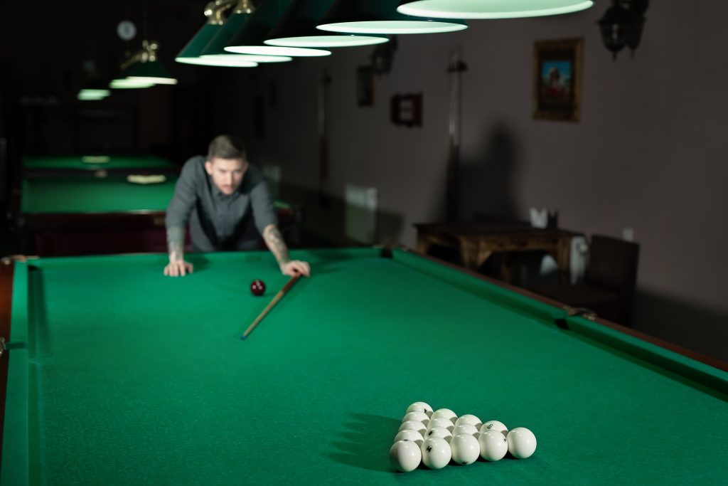 Man playing in Russian billiard at bar