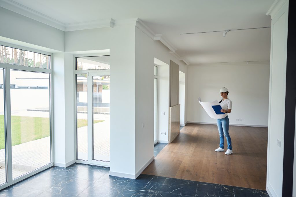 Woman Reviewing Blueprints in Bright Modern Home