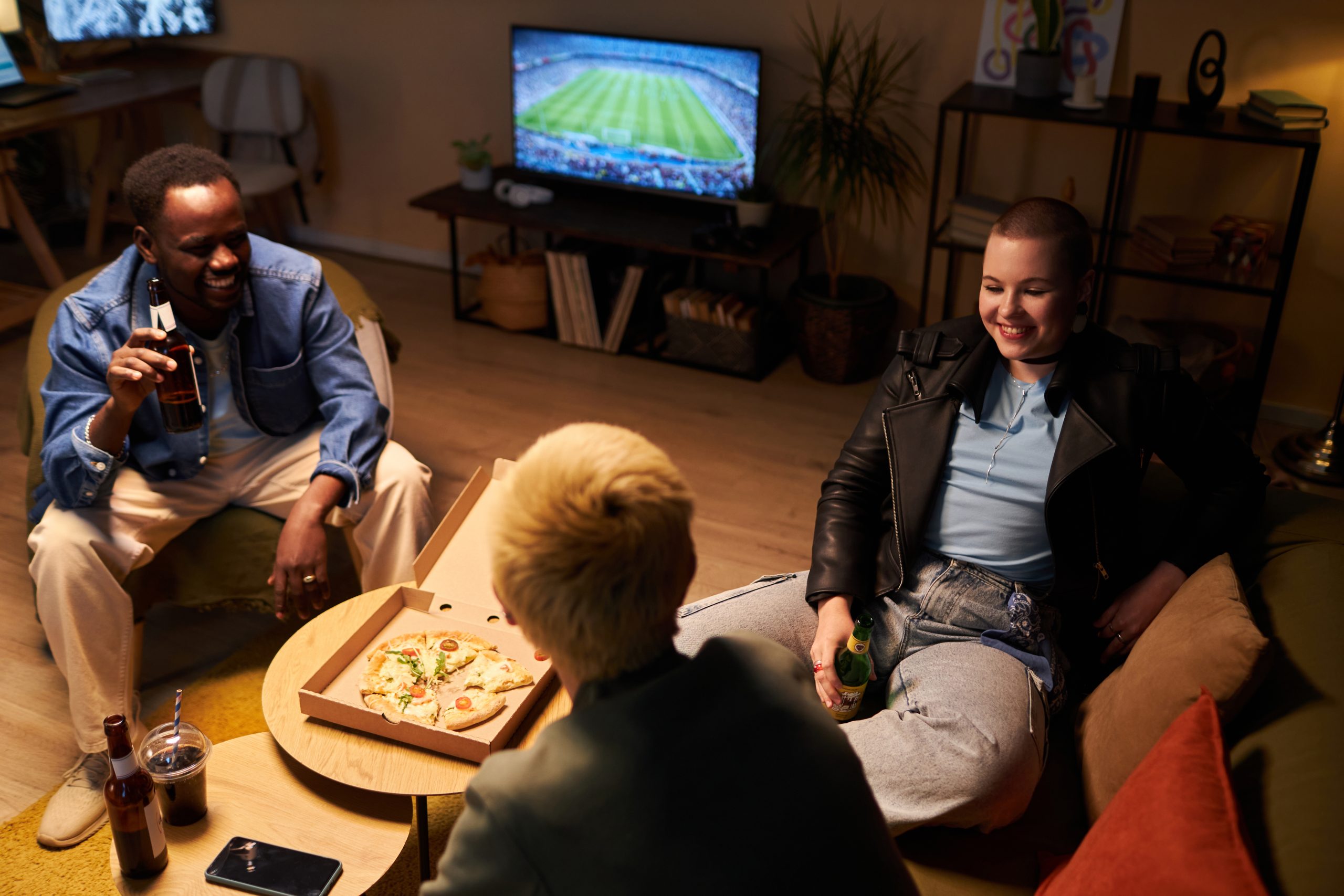 Young Friends Hanging Out at Home and Watching Football Young Friends Hanging Out at Home
