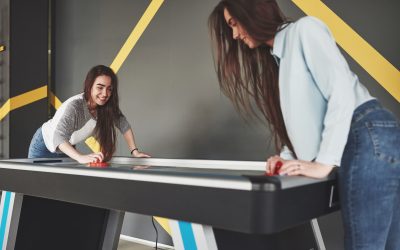 Young Women Playing Air Hockey Indoors