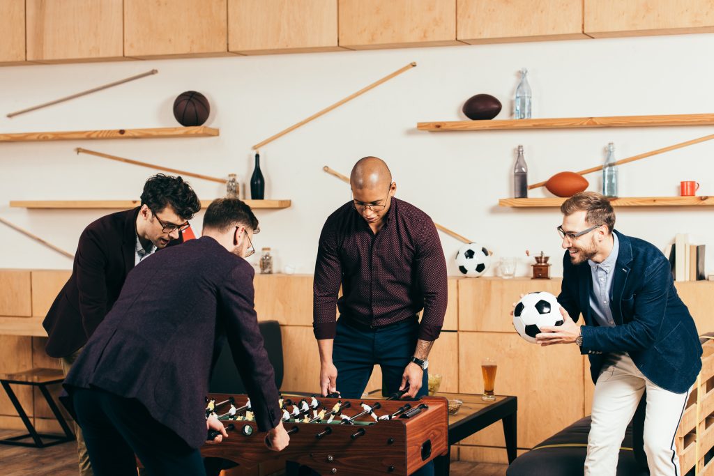 businessmen playing table football while resting in cafe