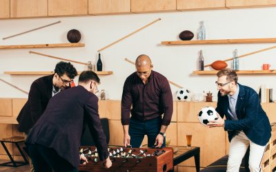 businessmen playing table football while resting in cafe