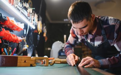 leather craftsman is carefully to make a leather product for a customer