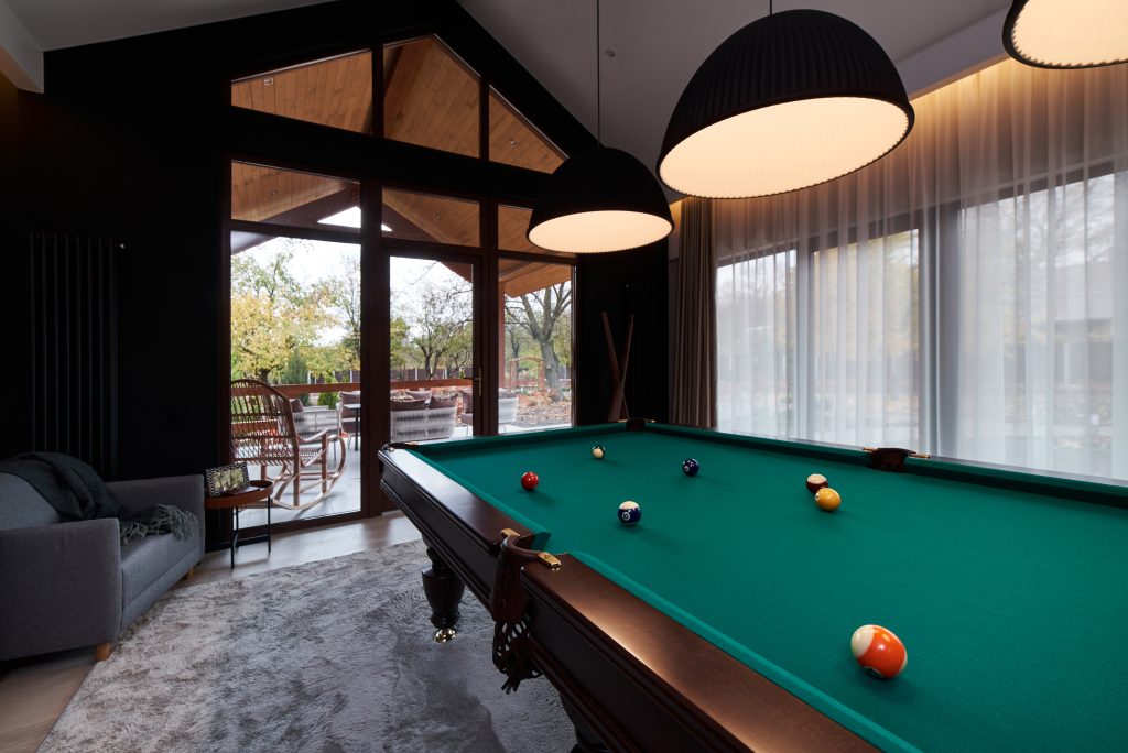 modern billiard room with a beautiful table and large windows