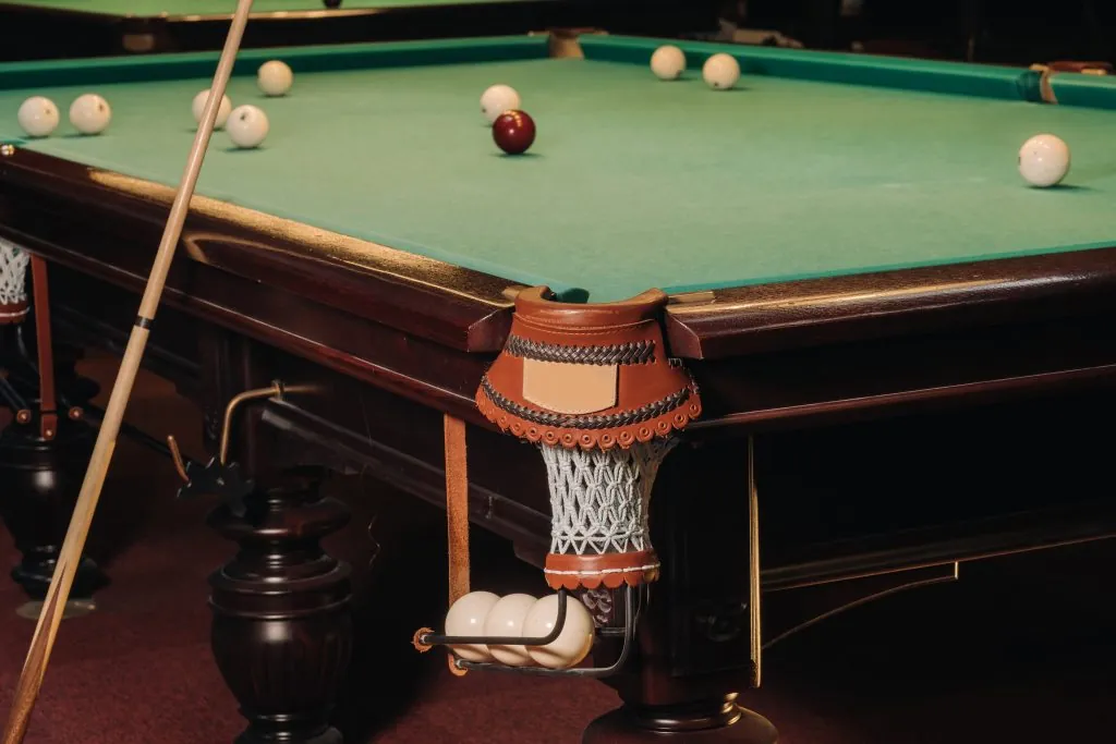 A pool table with balls that have already been played in the pool club
