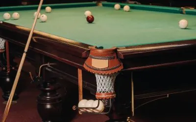 A pool table with balls that have already been played in the pool club